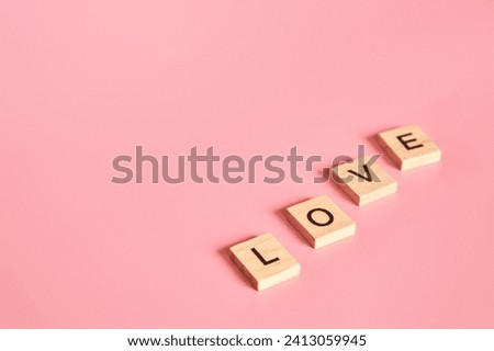 Letters of the English alphabet folded diagonally into the word love. Postcard concept with empty copy space. soft pastel delicate mat mistyrose pink background. Valentines Day, 14th of February Royalty-Free Stock Photo #2413059945