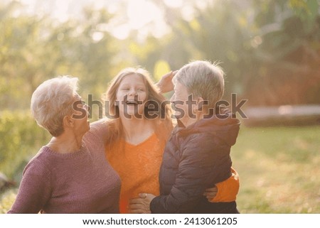 A Senior gay lesbian couple or family is having fun, hugging and enjoyรืเ their quality and memorable time with daughter or grandchild. Concept of lqbtq healthy relationship and bonding togetherness. Royalty-Free Stock Photo #2413061205