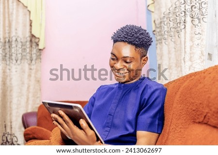 man sitting comfortably on a couch, engrossed in using a tablet to access various forms of entertainment and gather information.