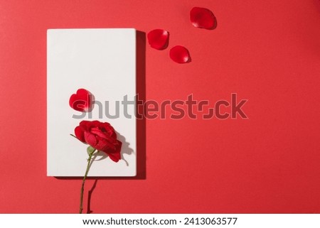 White podium in rectangle shaped arranged against red background with few rose petals. Product presentation, mockup, show cosmetic product, Podium, stage pedestal or platform