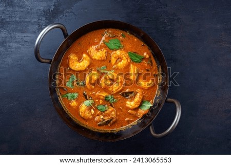 Traditional spicy Indian prawn Madras curry Rogan Josh with king prawns served as top view in a korei bowl with copy space  Royalty-Free Stock Photo #2413065553