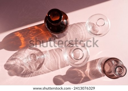 glass transparent vases on a pink background with beautiful lights