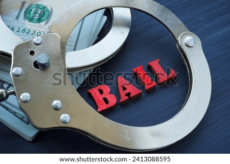 Bail bonds concept. The handcuffs are on the dollars. Royalty-Free Stock Photo #2413088595