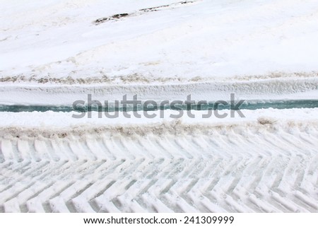 Tire tracks in snow on glacier ice
