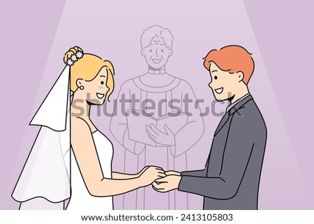 Marriage ceremony of man and woman holding hands, standing near altar with candlestick. Marriage of religious catholics wishing to get married and receive blessing from holy father Royalty-Free Stock Photo #2413105803