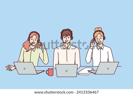 Call center employees with headsets for telephone sales sit at table with laptops and advise potential buyers. Call center with business people talking to clients via IP telephony. Royalty-Free Stock Photo #2413106467