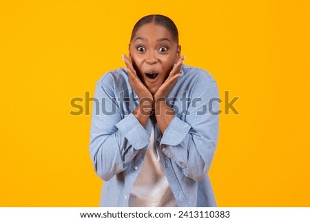Portrait of excited black young lady shouting OMG in excitement and touching face over yellow studio background, expressing emotion of joy. Unbelievable WOW offer, huge sale concept