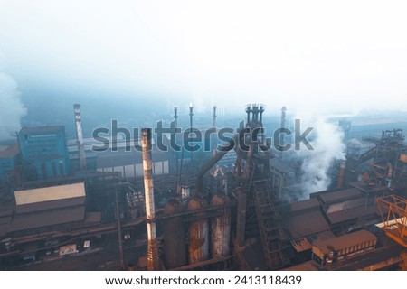 Industrial iron production factory during manifacture, aerial view from exterior,among smokes