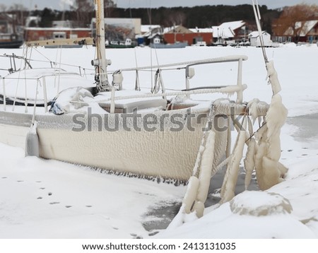 Spectacular ice formations on a boat cold and windy day. Natural phenomenon. Frozen ship in Nida port in Curonian spit, Lithuania Royalty-Free Stock Photo #2413131035