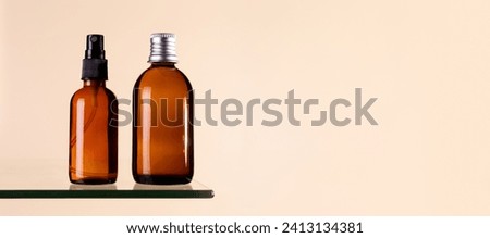 Two cosmetics dark amber glass bottles on beige background. Closeup, copyspace. Beauty blog, salon treatment concept, minimalism brand packaging mock up
 Royalty-Free Stock Photo #2413134381