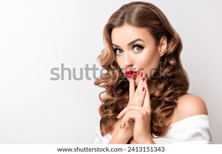 Woman surprise holds cheeks by hand .Beautiful girl  with curly hair  pointing to looking right . Presenting your product. Isolated on white background. Expressive facial expressions Royalty-Free Stock Photo #2413151343