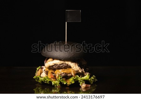 Black burger with double patty. Black background
