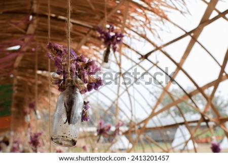 Purple bouquets flowers in a glass bottle hanging. Flower vase arrangements. Wedding floral decoration.