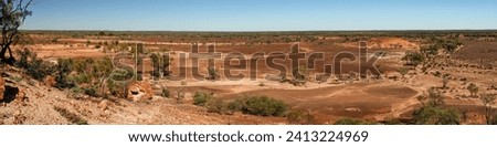 A mesa rock formation with small caves in its escarpments locally known as "Cave Hill" in the Australian outback Royalty-Free Stock Photo #2413224969