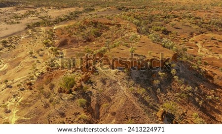 A mesa rock formation with small caves in its escarpments locally known as "Cave Hill" in the Australian outback Royalty-Free Stock Photo #2413224971