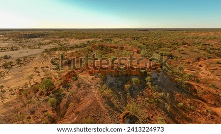 A mesa rock formation with small caves in its escarpments locally known as "Cave Hill" in the Australian outback Royalty-Free Stock Photo #2413224973