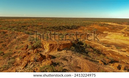 A mesa rock formation with small caves in its escarpments locally known as "Cave Hill" in the Australian outback Royalty-Free Stock Photo #2413224975
