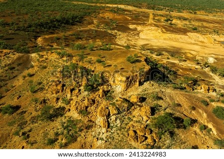 A mesa rock formation with small caves in its escarpments locally known as "Cave Hill" in the Australian outback Royalty-Free Stock Photo #2413224983