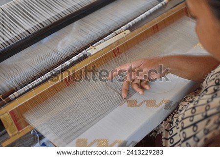 weaving craftsmen who is weaving cloth using traditional looms in donggala, Indonesia