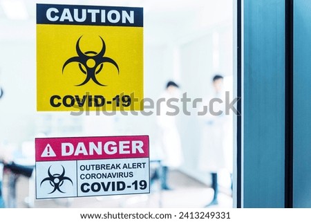 Biohazard disease alert corona outbreak sign on glass wall laboratory science center. Medical care clinic with hazard alert sign. Medical Healthcare concept.