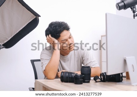 Tired photographer working at his workplace.