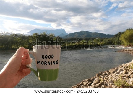 Cut out woman hand holding a mug with text written - Good Morning
