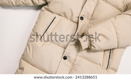 Childrens winter jacket. Stylish childrens beige warm down jacket isolated on white background. Winter fashion. Royalty-Free Stock Photo #2413288651