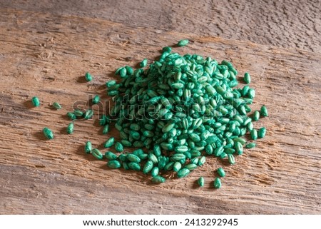 A pile of poisoned wheat for rodent bait. Poisonous grain on wooden boards. Extermination of harmful rodents in agriculture. Royalty-Free Stock Photo #2413292945