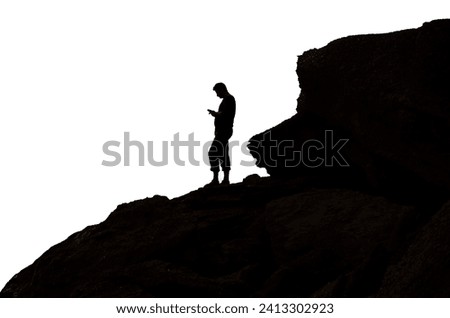 a man stands on a rock with a phone in his hand, silhouette for your design