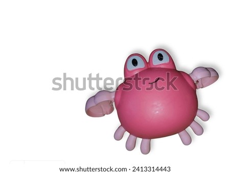 Mechanically rotated pink crab toy. Clockwork plastic toy isolated on white background.
