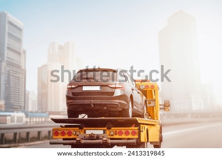 A tow truck recovery with a flatbed can transport your vehicle to safety and provide roadside assistance. Royalty-Free Stock Photo #2413319845
