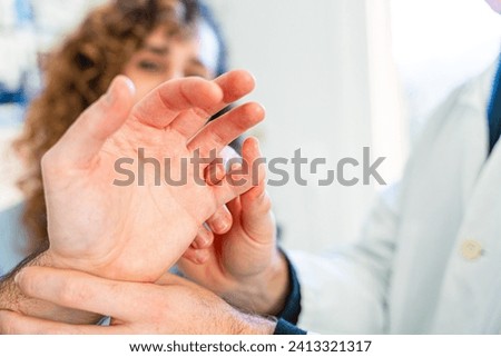 Close-up of a doctor examining a hand of a patient in the hospital