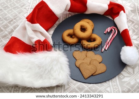 Holidays celebrations serving and eating gingerbread donut holes candy cane and coffee mugs Merry Christmas and Happy New Years with Santa Claus hat decoration at the dessert table