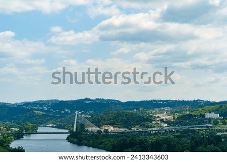Scenery of Coimbra City in the summertime with the Mondego River and surrounding trees under a clear sky. Landscape background and wallpaper. Royalty-Free Stock Photo #2413343603
