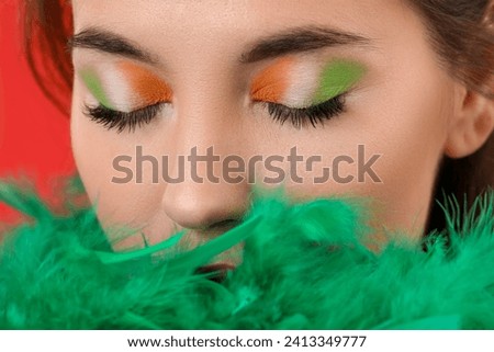 Young woman with green feather boa and makeup for St. Patrick's Day, closeup