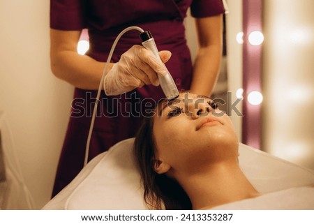 Young caucasian woman on microcurrent therapy procedure. Beautician's office. High quality photo
