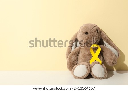 A soft toy bunny with a yellow ribbon