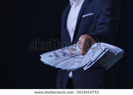 Man offers  set of bills worth hundred dollars. Hands close up. Venality, bribe, corruption concept. Hand giving money. Hand receives money from businessman. Royalty-Free Stock Photo #2413414753