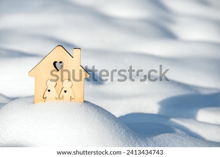 The symbol of the house stands among the snow-covered landscape
