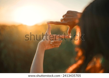 Closeup of woman hands making frame gesture with sunset, Female capturing the sunrise. Future planning concept.