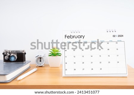 Desktop Calendar for February 2024 year and vintage camera with diary for Planner to plan timetable at Home Office.