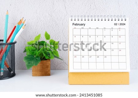 February 2024 Desk Calendar with pencil on white table.