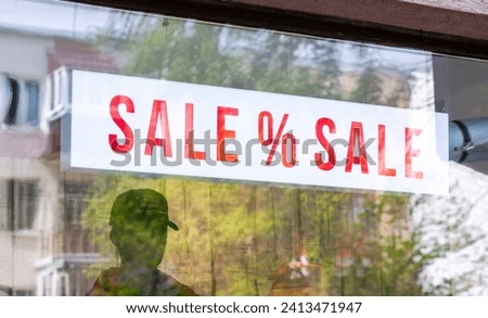 Large inscription Sale on a window display of a clothing store. Shopping, sales, retail