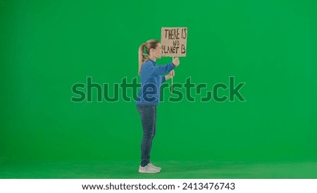 A side view of a screaming female activist holding a sign saying There is no planet B. A female protester with a placard on a green screen. Save the planet, global warming and climate change.