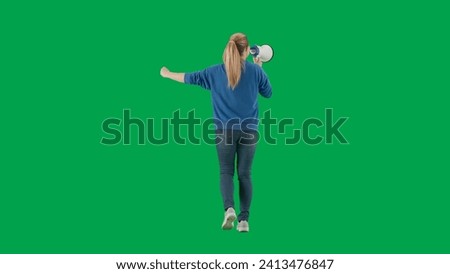 Woman facing away from camera speaking into megaphone with raised fist. Back view of a woman with a mouthpiece on a green screen. Protest action, fight for women's rights, strike.
