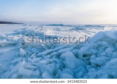 Landscape photo with ice hummocks and snow on a frozen Baltic Sea surface on a sunny winter day