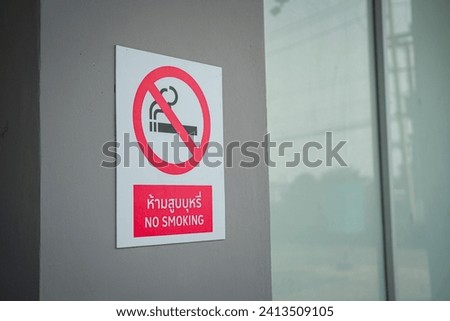 "No smoking" sign with red circle icon (Thai and English text) that showed on the building part. Sign and symbol for healthcare, selective focus.