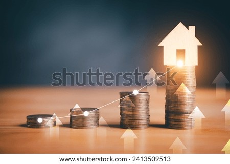 Stacks of coins with glowing house icon and upward arrows, symbolizing real estate investment growth.