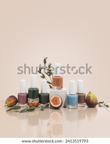 Fall nail polish collection on tan background with leaves and figs on beige background