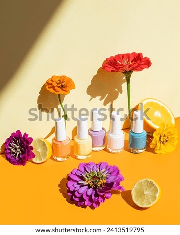 Spring and summer nail polish colors on yellow background with flowers and lemons
